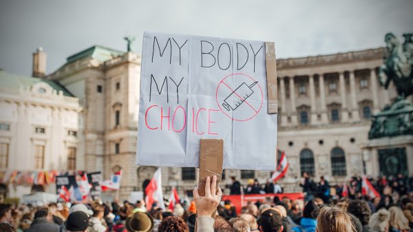 Hand drawn sign that says "My body my choice" next to a syringe
