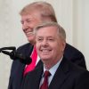 Lindsey Graham standing in front of Donald Trump