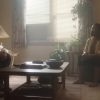 Still image from trailer depicting Dahmer and a black woman sitting in a livingroom