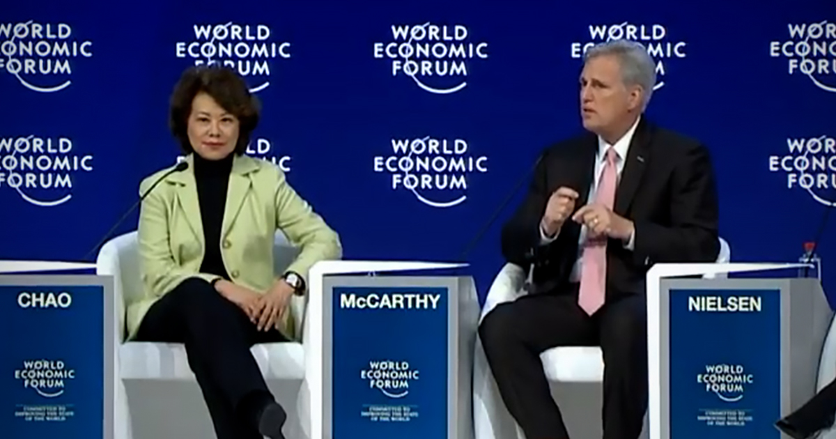 Elaine Chao and Kevin McCarthy sit against a screen that says World Economic Forum