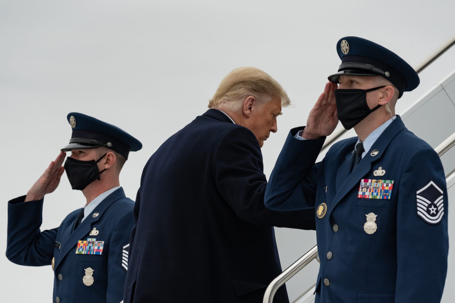 Trump enters Air Force One while flanked by masked Marines
