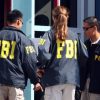 Three FBI agents stand in a circle