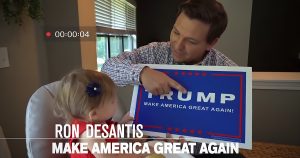 Ron DeSantis holding a Trump sign with his daughter