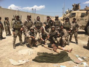 Gallagher and a group of seals pose around a dead ISIS fighter