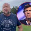 Alex Jones outside with a photo of Tucker Carlson