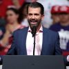 Donald Trump Jr. with hands outstretched at a rally