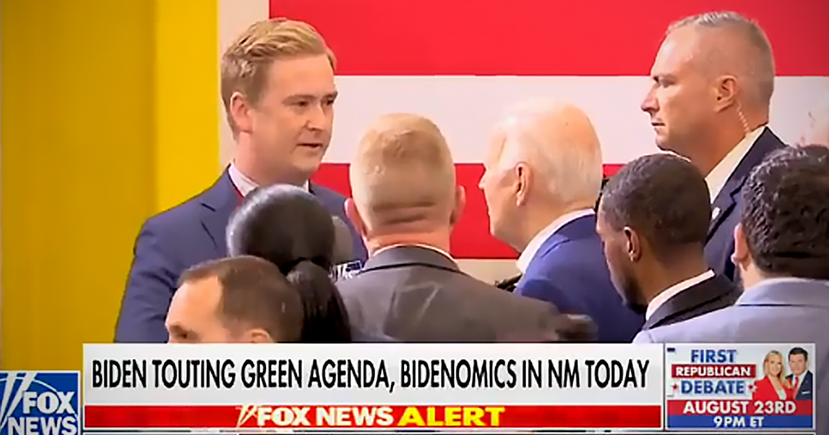 Peter Doocy and Joe Biden stand in a a crowd on stage