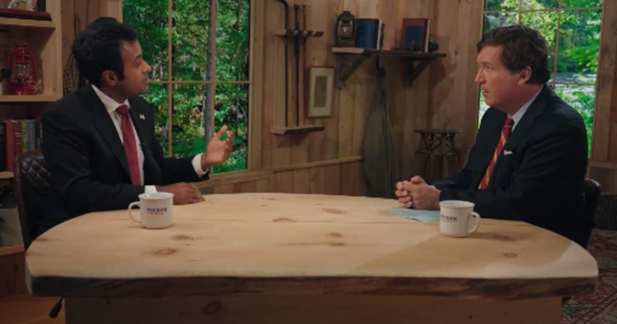 Vivek Ramaswamy and Tucker Carlson sit at a table
