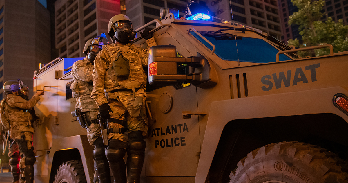 Police stand on an armored vehicle emblazoned with "Atlanta Police Department SWAT"