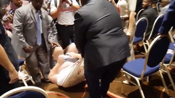 Alex Rosen dragged by his shirt by a group of black men wearing suits